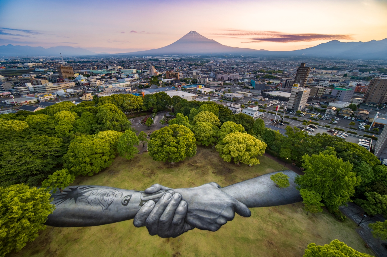 Giant hands stretching across the globe just reached Japan